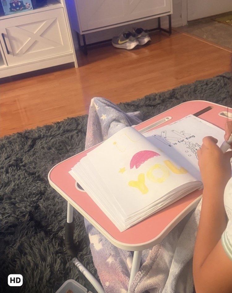 Girl coloring the book at home